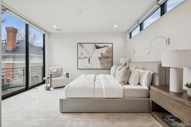 a bedroom with a bed and large window