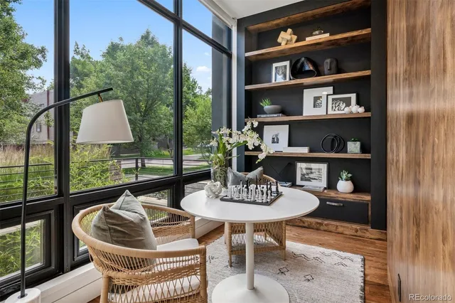 a dining room with furniture and a floor to ceiling window