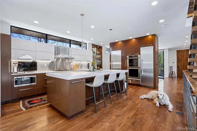 a kitchen with stainless steel appliances granite countertop a refrigerator and a stove top oven