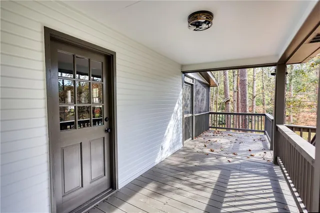 a view of a hallway with wooden floor and windows