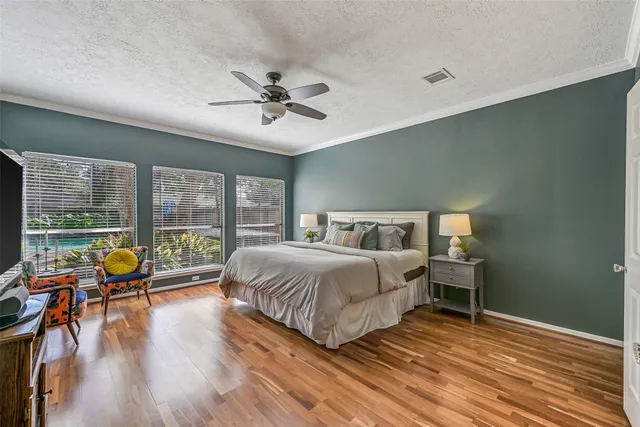 a spacious bedroom with a bed and wooden floor