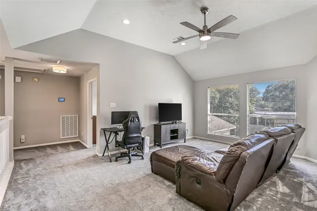 a living room with furniture ceiling fan and a window