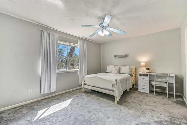 a spacious bedroom with a bed and a window