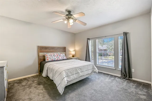 a spacious bedroom with a large bed and a chandelier