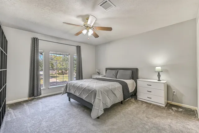 a spacious bedroom with a bed and a chandelier