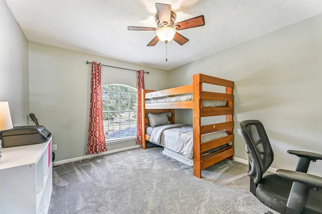 a bedroom with a bed and a ceiling fan