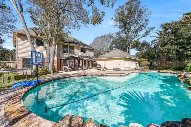 a view of a house with pool and sitting area