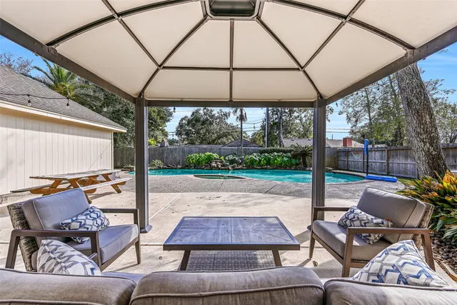 a outdoor space with the couches and dining table with the garden view