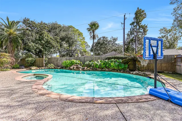 a view of a garden with a bench and trees in the background