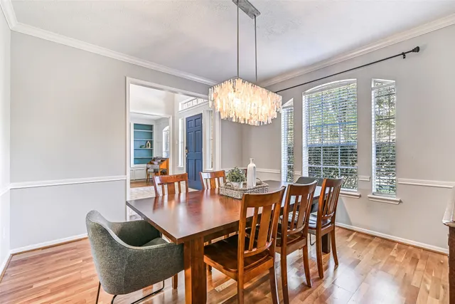 a dining room with furniture a chandelier and wooden floor