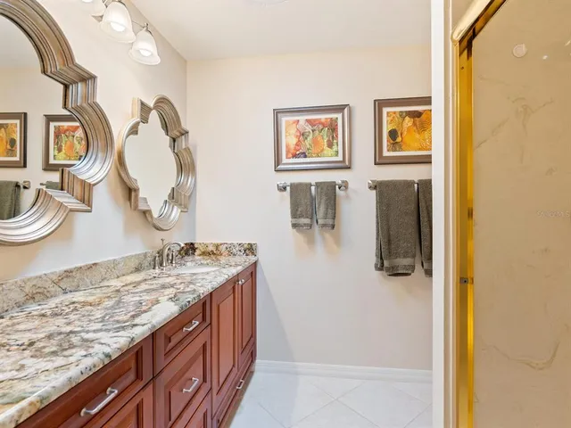 a bathroom with a granite countertop sink and a mirror