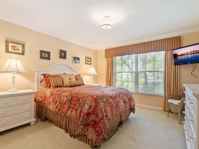 a bedroom with a bed and a large window