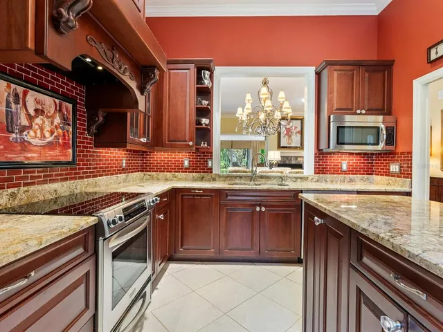 a kitchen with stainless steel appliances granite countertop a stove a sink and a microwave