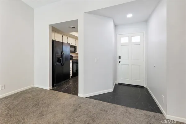 a view of an empty room with a fireplace and a window
