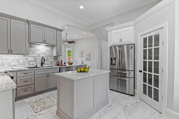 a kitchen with white cabinets and stainless steel appliances