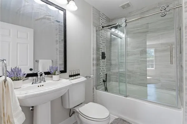 a bathroom with a sink toilet and shower