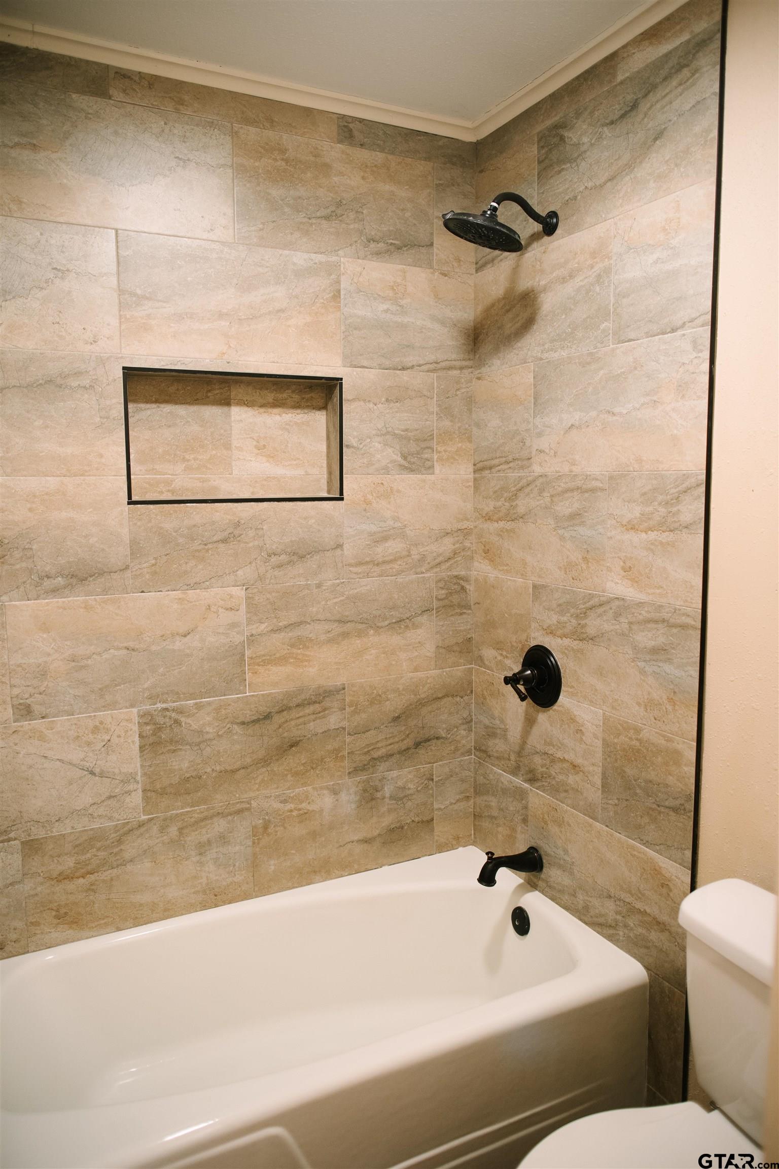 1823 Overbrook Drive Tyler, TX 75703 - Photo 19 of 48 a bathroom with a bathtub and a shower