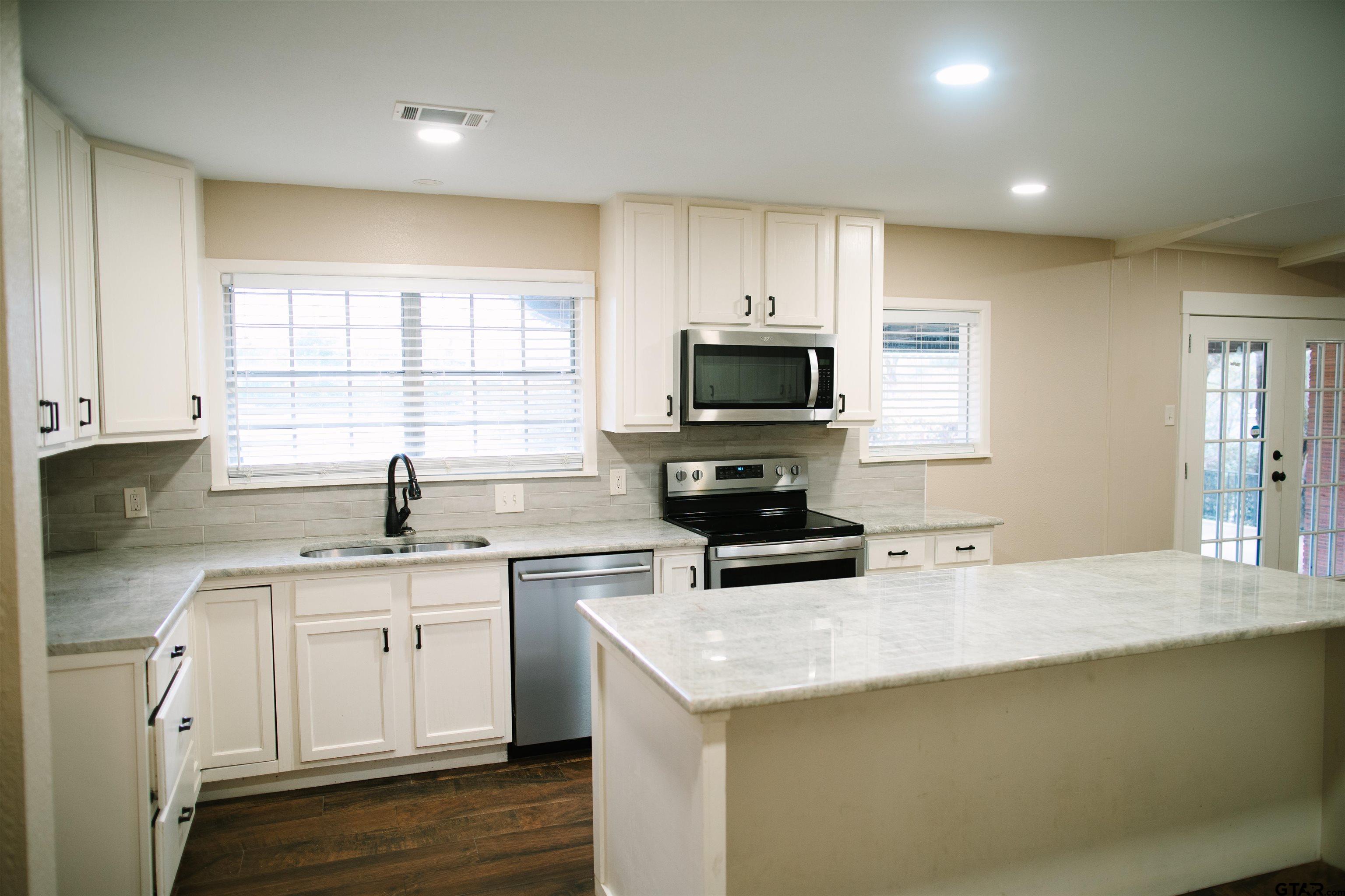 1823 Overbrook Drive Tyler, TX 75703 - Photo 2 of 48 a kitchen with a sink a window and appliances