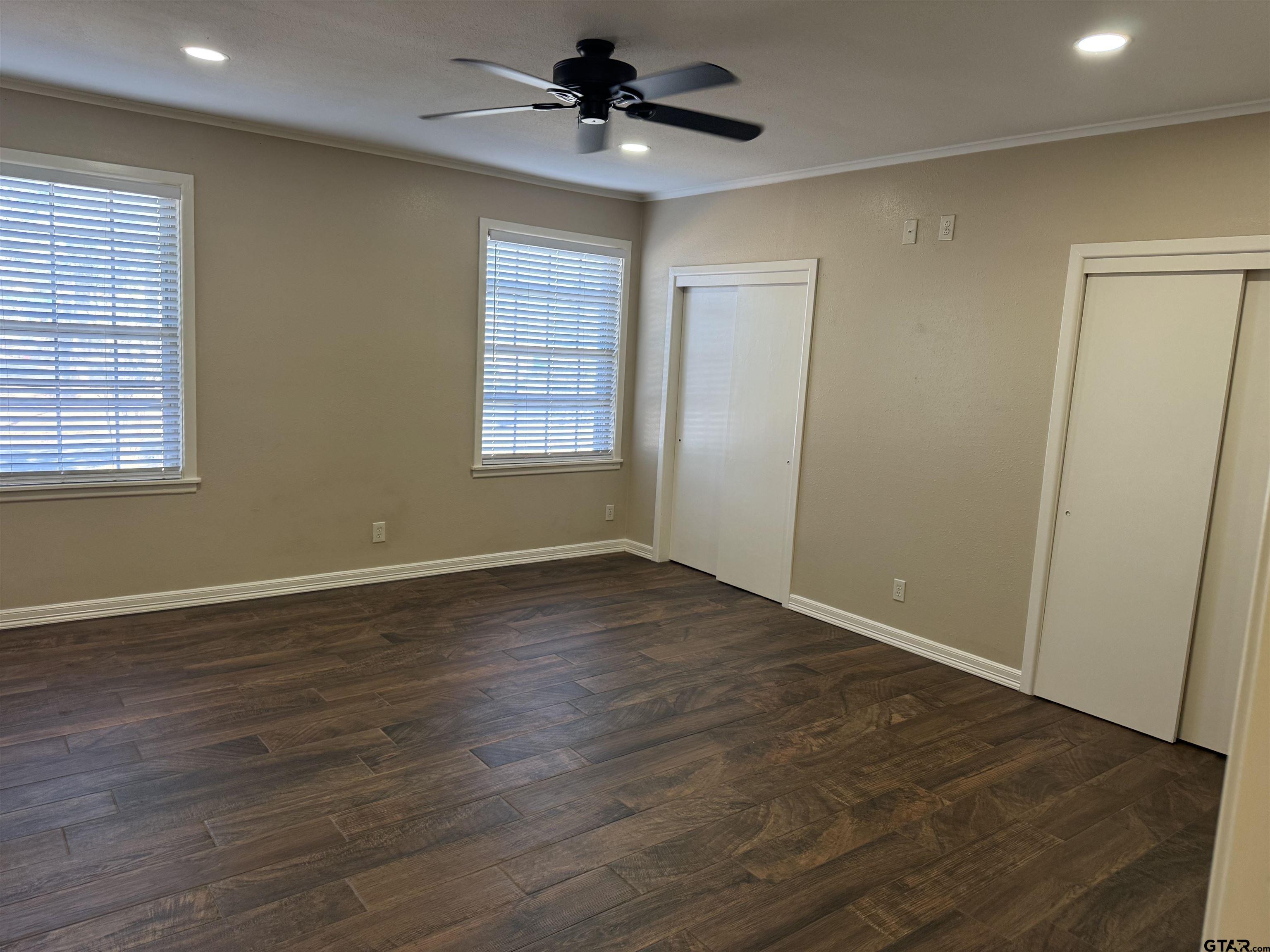 1823 Overbrook Drive Tyler, TX 75703 - Photo 33 of 48 an empty room with wooden floor chandelier fan and windows