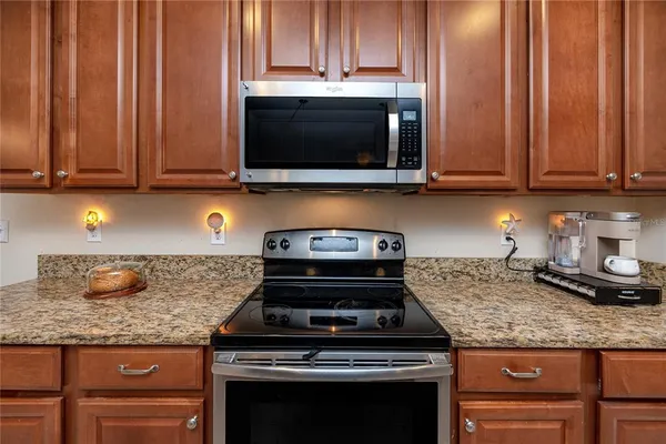 a kitchen with granite countertop wood cabinets and stainless steel appliances