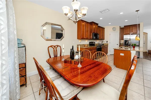 a dining room filled chandelier and wooden floor