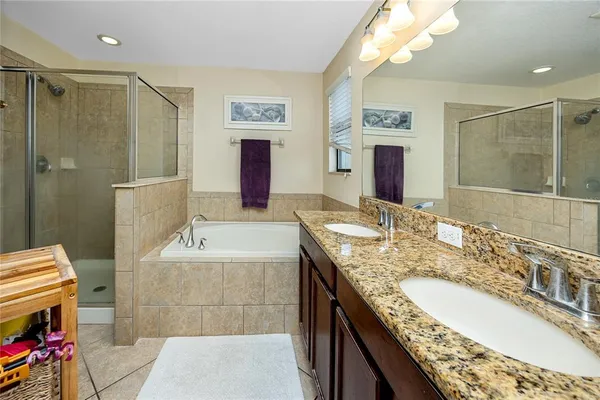 a bathroom with a granite countertop tub sink and mirror