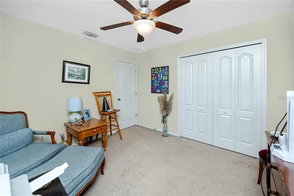 a living room with furniture and a ceiling fan