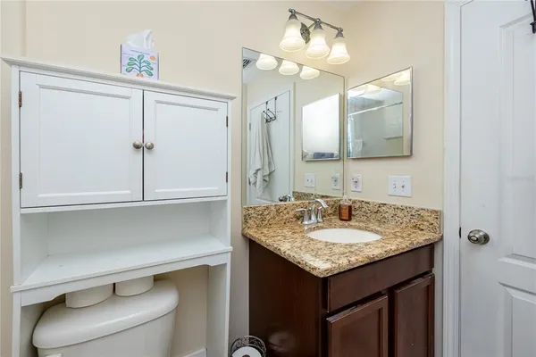 a bathroom with a granite countertop sink and a mirror