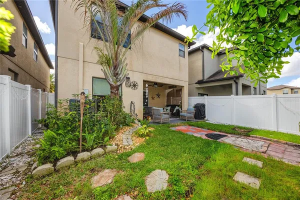 a backyard of a house with table and chairs plants