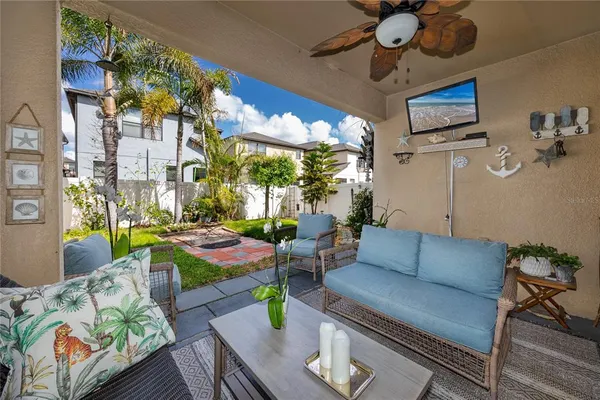 a living room with patio furniture and a floor to ceiling window