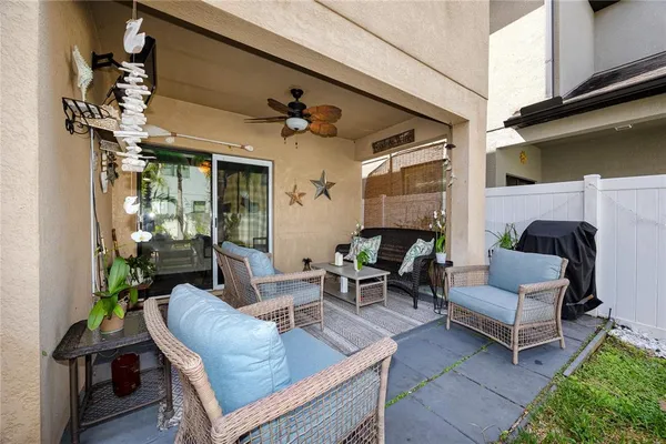 a view of a patio with couches table and chairs and potted plants