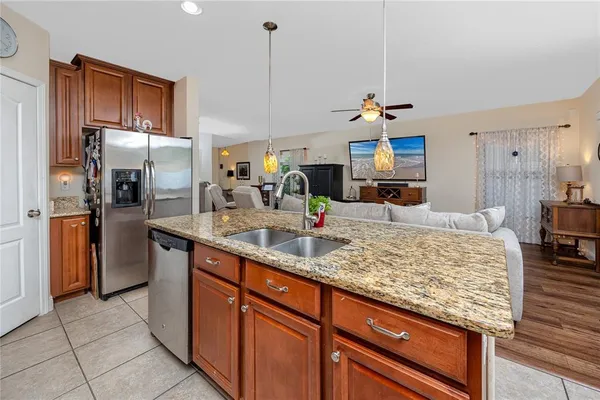 a kitchen with stainless steel appliances granite countertop a sink refrigerator and cabinets
