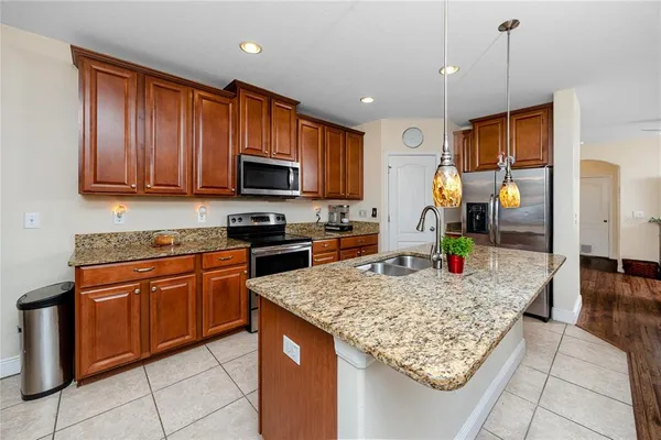 a kitchen with stainless steel appliances granite countertop a stove top oven a sink a counter top space and cabinets