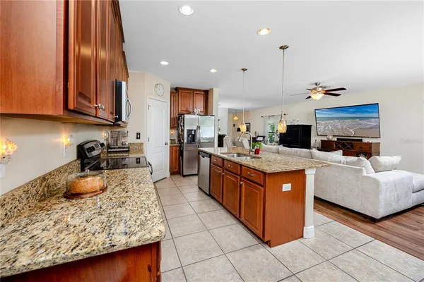 a large kitchen with stainless steel appliances granite countertop a stove a sink dishwasher and a refrigerator