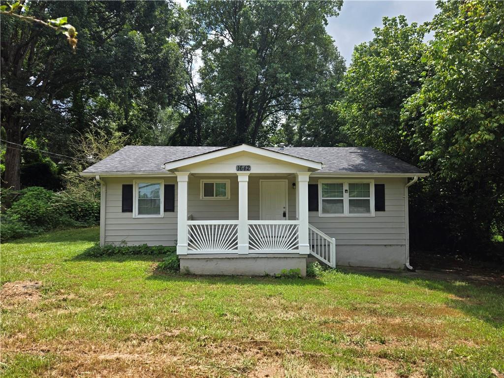 1642 Mary George Avenue Northwest Atlanta, GA 30318 - Photo 1 of 33 a front view of a house with a garden