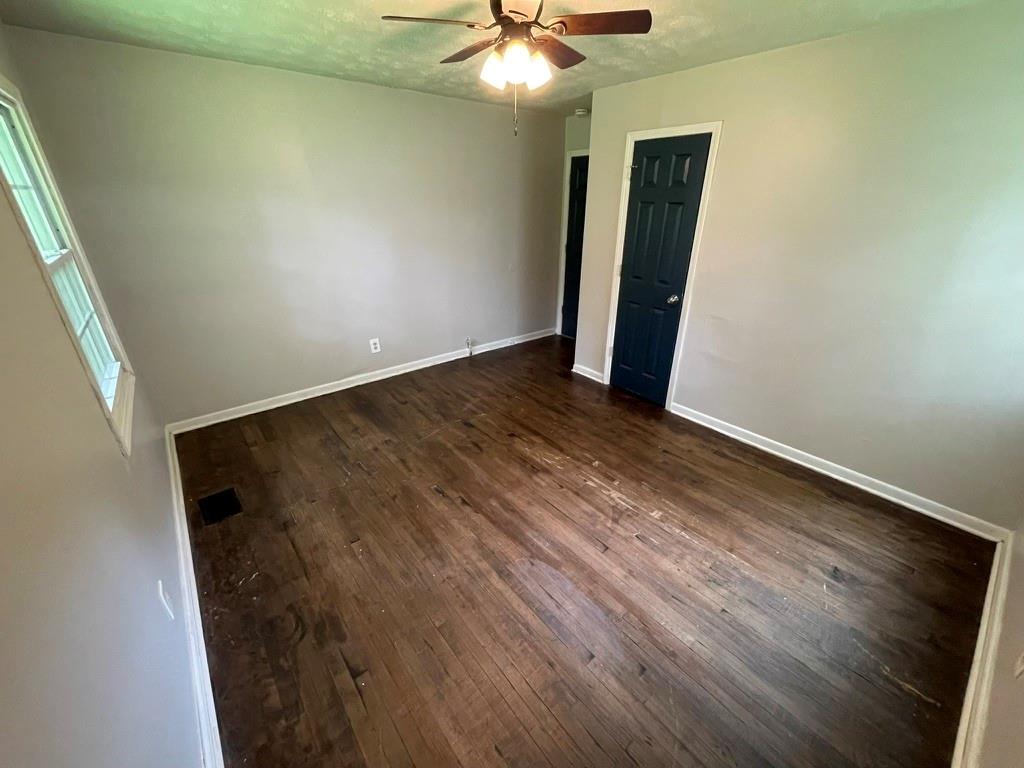 1642 Mary George Avenue Northwest Atlanta, GA 30318 - Photo 22 of 33 an empty room with wooden floor and chandelier fan