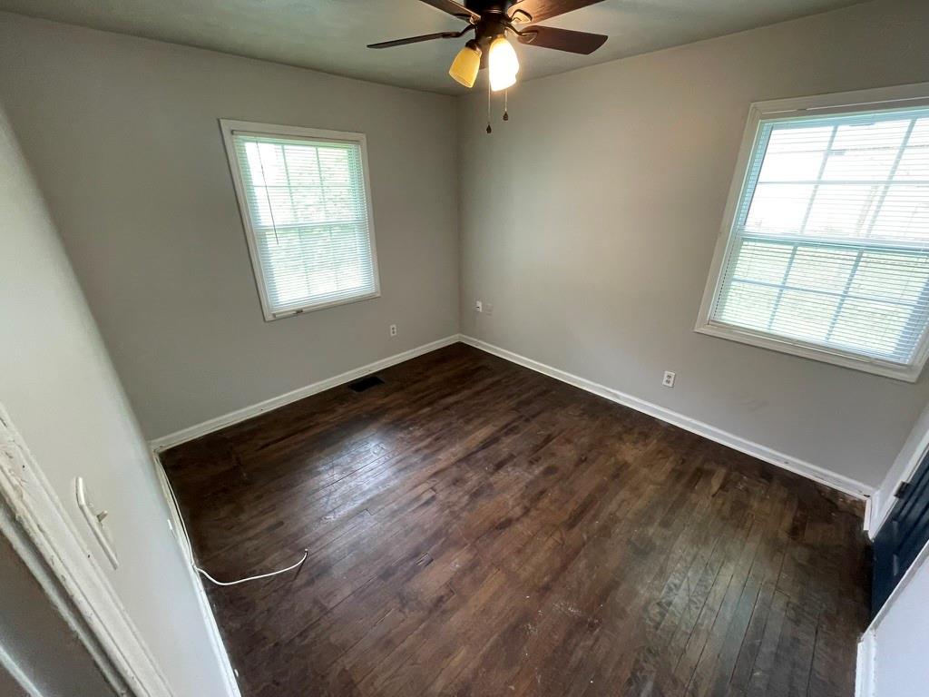 1642 Mary George Avenue Northwest Atlanta, GA 30318 - Photo 26 of 33 an empty room with wooden floor fan and windows