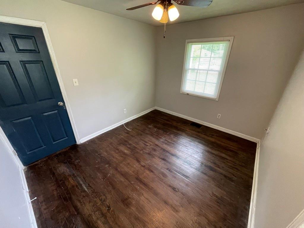 1642 Mary George Avenue Northwest Atlanta, GA 30318 - Photo 27 of 33 an empty room with wooden floor fan and windows