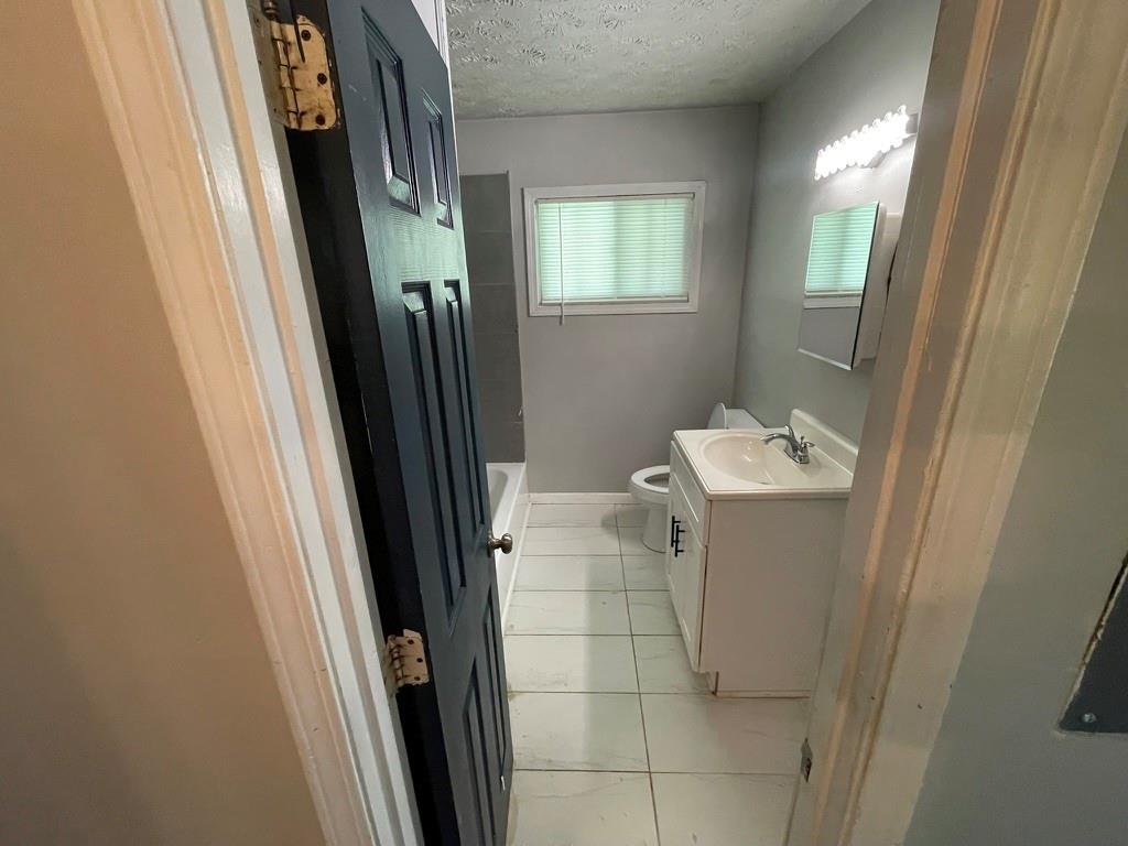 1642 Mary George Avenue Northwest Atlanta, GA 30318 - Photo 28 of 33 a bathroom with a sink toilet and mirror