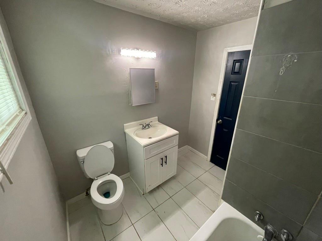 1642 Mary George Avenue Northwest Atlanta, GA 30318 - Photo 29 of 33 a bathroom with a toilet sink and mirror