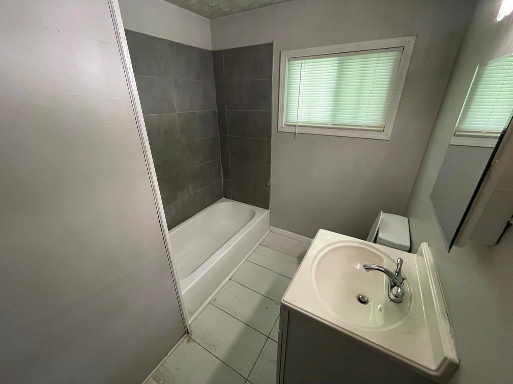 1642 Mary George Avenue Northwest Atlanta, GA 30318 - Photo 31 of 33 a bathroom with a sink a mirror and shower