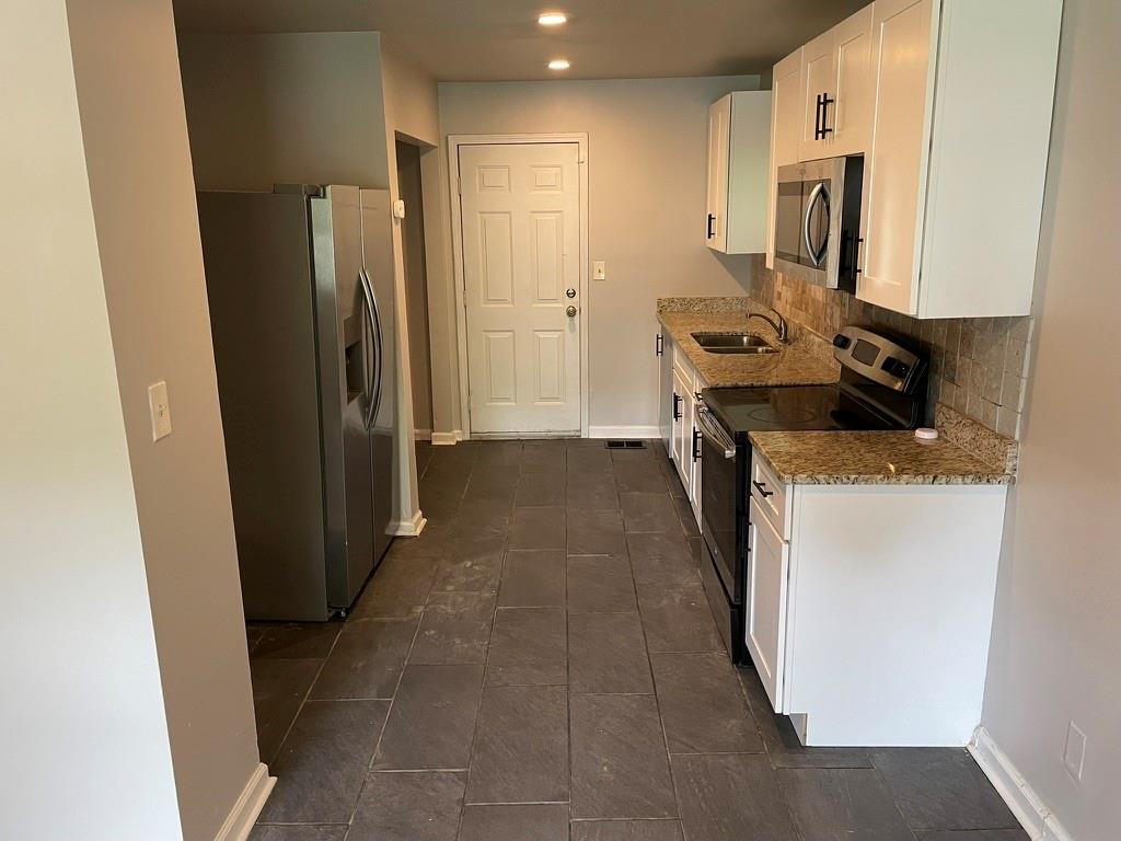 1642 Mary George Avenue Northwest Atlanta, GA 30318 - Photo 8 of 33 a kitchen with a refrigerator and a stove