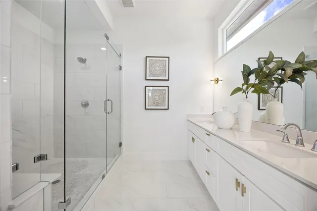 a bathroom with a granite countertop sink a mirror and a shower