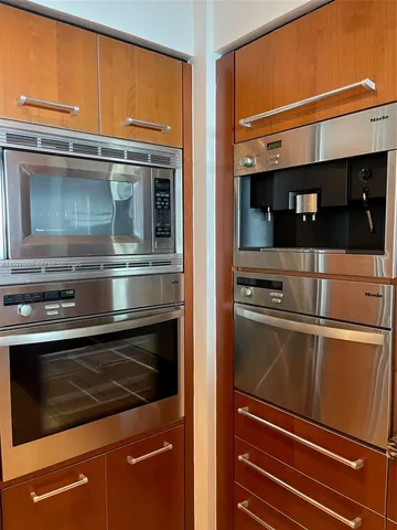a kitchen with stainless steel appliances granite countertop a refrigerator and a stove top oven