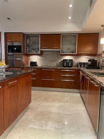 a view of a kitchen with kitchen island a sink stainless steel appliances and cabinets
