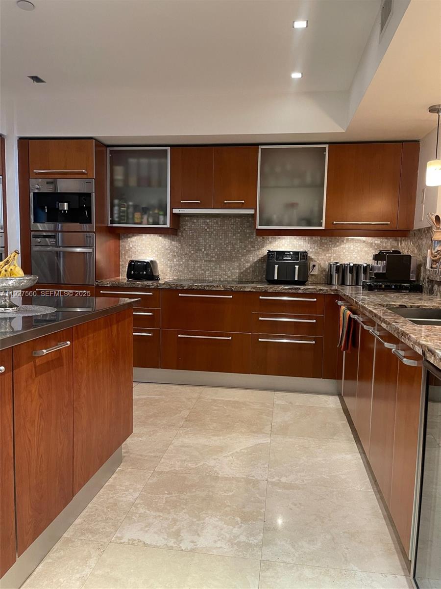 1331 Brickell Bay Drive, Unit 3607 Miami, FL 33131 - Photo 19 of 35 a kitchen with stainless steel appliances granite countertop a stove top oven sink and cabinets