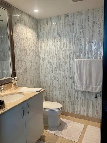 a bathroom with a sink a toilet and mirror