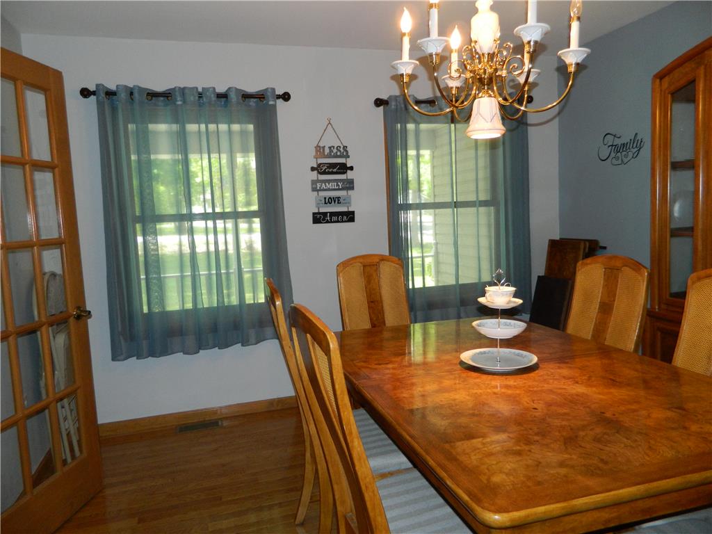 328 Pin Oak Road Stroudsburg, PA 18360 - Photo 13 of 37 Hardwood flooring extends throughout this well-lit dining room, featuring elegant window treatments and a classic chandelier.