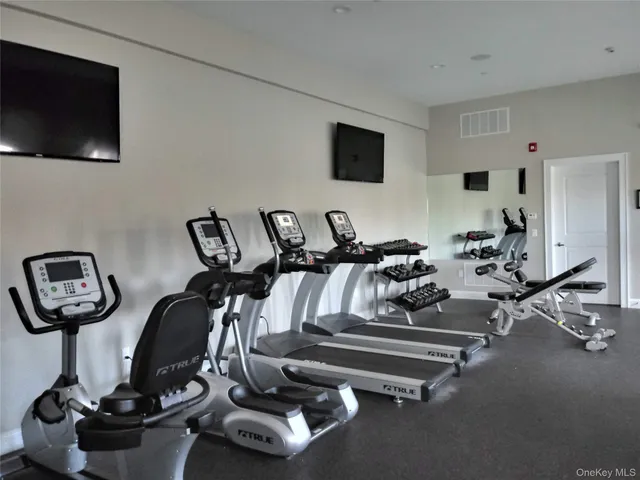 a room with gym equipment and a flat screen tv