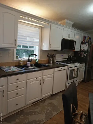 a kitchen with stainless steel appliances granite countertop a sink a stove and a microwave